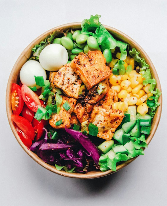 Gesunde, kalorienarme Bowl mit Salat, Gemüse, Ei und Lachs