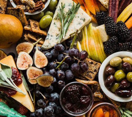 Käseplatte mit einer großen Auswahl an Käsen, Früchten und Knabbereien